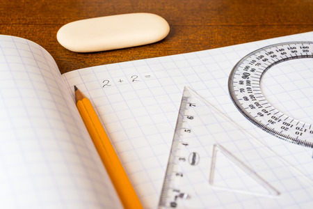 Solving mathematical problems, a notebook with drawing tools on the tableの写真素材