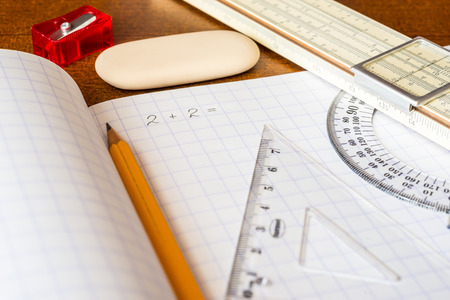 Solving mathematical problems, a notebook with drawing tools on the tableの写真素材