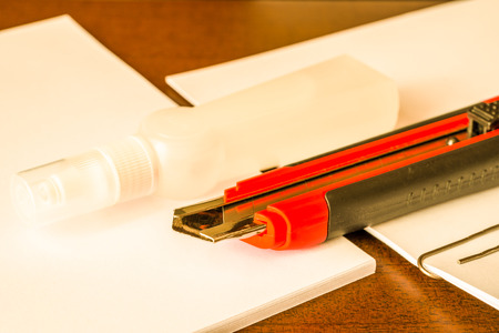 Stationery on the desk in the office, a knife on the paper with a glue. In yellow tonesの写真素材