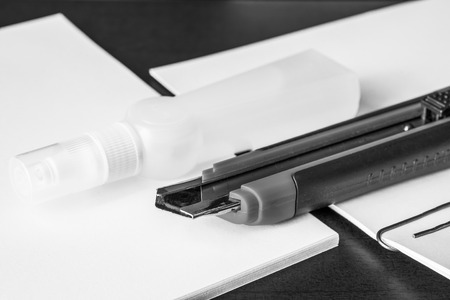 Stationery on the desk in the office, a knife on the paper with a glue. In black and white tonesの写真素材