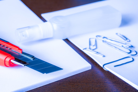 Stationery on the desk in the office, a knife on the paper with a clips. In blue tonesの写真素材