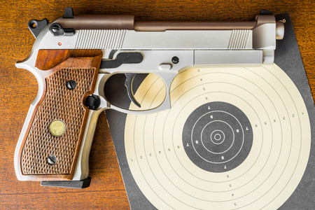 Target shooting, the gun and the target on the table. Top viewの写真素材