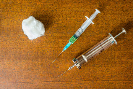 Cure the disease, a two syringe for injection with wadding on the tableの写真素材