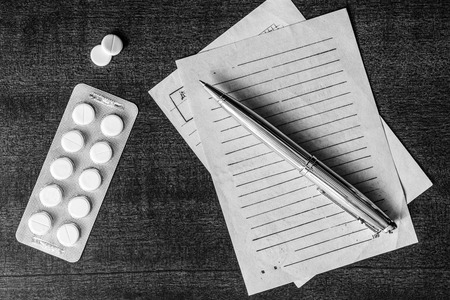 Cure the disease, prescribe the right tablets, recipe and pen on the table. In black and white tonesの写真素材