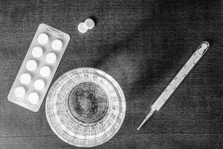 Cure the disease measure temperature by thermometer and take the pillsの写真素材