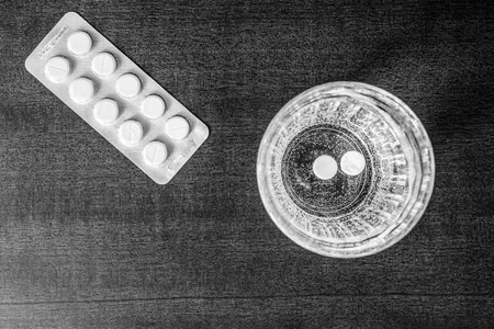 Cure the disease couple of tablets dissolve in a glass of water. Focus on the glass of waterの写真素材