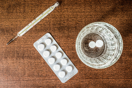 Cure the disease couple of tablets dissolved at a temperature of the glass of water. Focus on the glass of water in retro tonesの写真素材