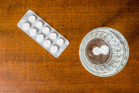 Cure the disease couple of tablets dissolve in a glass of water. Focus on the glass of waterの写真素材