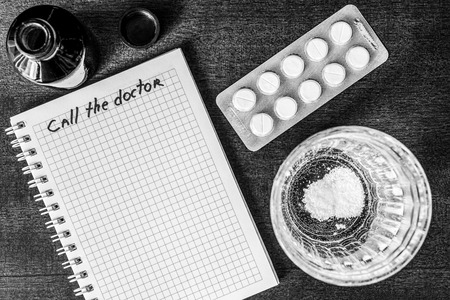 Call the doctor couple of tablets dissolve in a glass of water. Focus on the glass of waterの写真素材