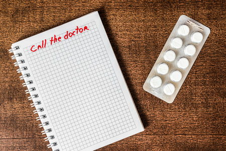 Call the doctor take the pills on the table. In retro tonesの写真素材