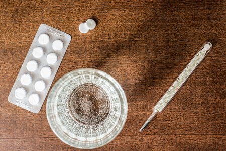 Cure the disease measure temperature by thermometer and take the pills in retro tonesの写真素材
