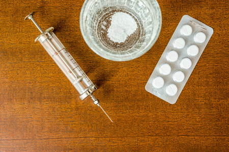 Cure the disease couple of tablets dissolve in a glass of water and a syringe. Focus on the glass of waterの写真素材