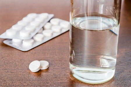 Cure the disease take the pills on the table and drinking water. Angle viewの写真素材