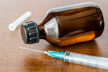 Cure the disease a solution and a syringe for injection on the tableの写真素材