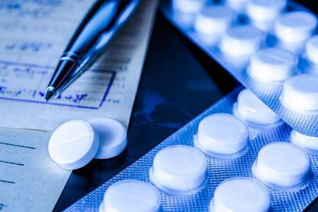 Xray examination a prescription and tablets for treatment of disease a pen on the recipe. Focus on the pills in blue tonesの写真素材