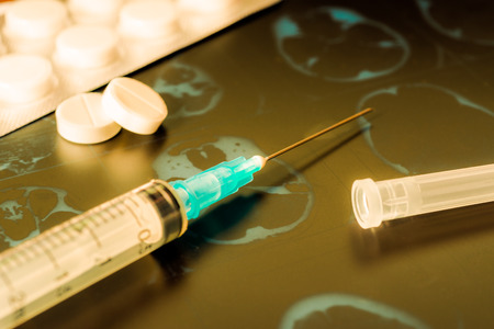Xray examination syringe for injection a two pills for treatment of disease. In yellow tonesの写真素材