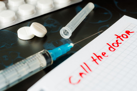 Call the doctor xrays and syringe injection with pills on the tableの写真素材