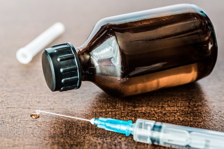 Cure the disease, a solution and a syringe for injection, drug flow from the syringe. Angle viewの写真素材