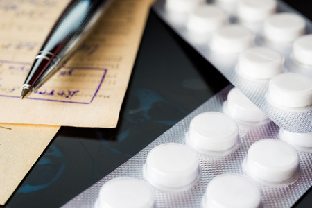 X-ray examination, a prescription and tablets for treatment of disease, a pen on the recipe. Focus on the pillsの写真素材