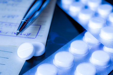 X-ray examination, a prescription and tablets for treatment of disease, a pen on the recipe. Focus on the pillsの写真素材