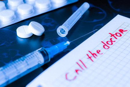 Call the doctor, x-rays and syringe injection with pills on the tableの写真素材