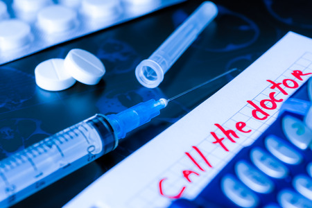 Call the doctor, x-rays and syringe injection with pills and phone on the tableの写真素材