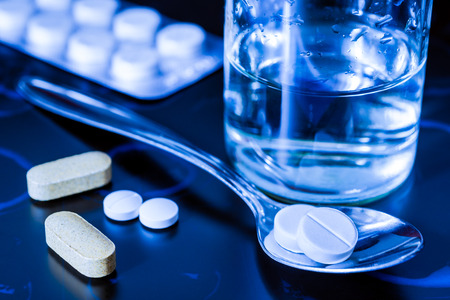 Take tablets, X-rays with pills and vitamins with a glass of water on the tableの写真素材