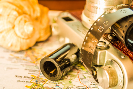 Vacation planning, souvenirs with camera and map of the area on the tableの写真素材
