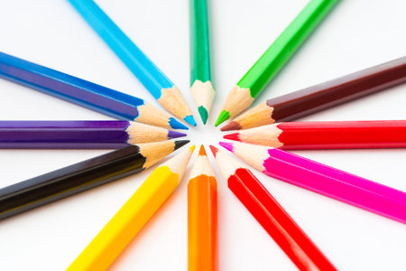 Colored pencils in a circle on the paper. Angle view, in soft lightの写真素材