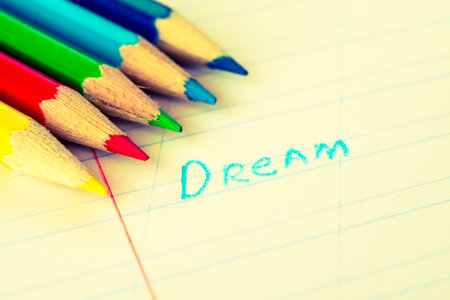 Word dream written in a notebook with colored pencils. Image in the yellow-blue toningの写真素材