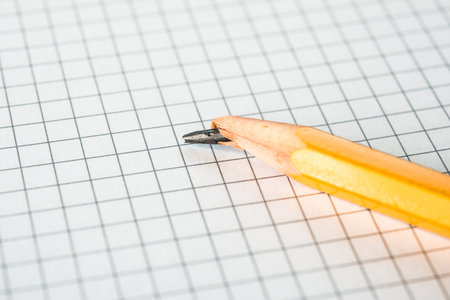 Broken pencil lying on a notepadの写真素材