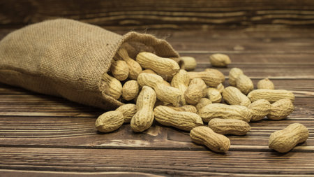 Peanuts in a bag on a woody background