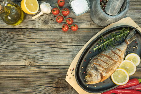 Grilled gilthead in pen on wooden background