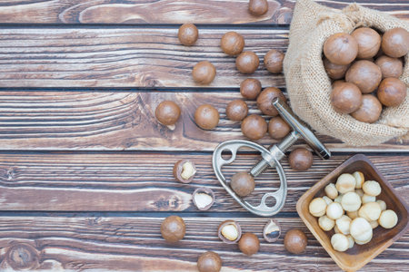 Macadamia nuts in bowl and sack on wooden backgroundの写真素材