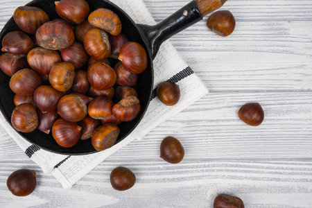 Chestnuts in a pan on a wooden backgroundの写真素材