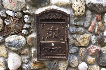 Old traditional post box, on a stone wallの写真素材