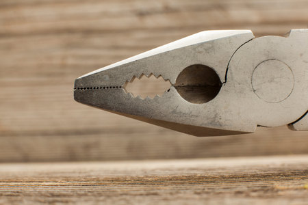 close up view of a pliers in wooden background