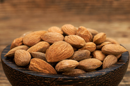 Bowl of almonds on wooden table.の写真素材
