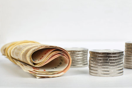 Euro coins stacks and roll of banknotes.