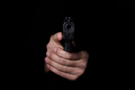 Closeup view of man's hands aiming with gun.の写真素材
