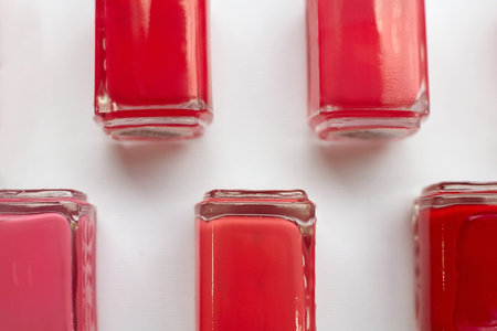 Red polish bottles over white background.