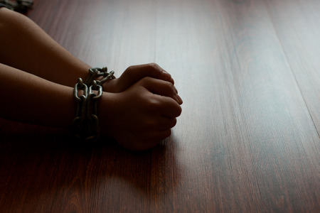 Kid's hands tied with chain.の写真素材