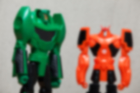 Blur image of green and orange robots on grey background.の写真素材