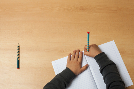 Child writes on a notebook.の写真素材