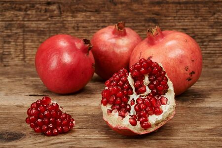 ripe pomegranate fruits on wooden table.の写真素材