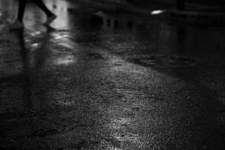 lights and shadows on wet road at rainy night.の写真素材