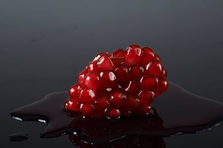 pomegranate seeds and juice on black background.の写真素材