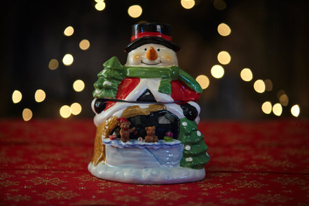 Christmas snowman ornament on lights background.