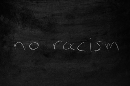 the words "no racism" written on a blackboardの写真素材