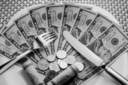 Cutlery with money on a white plateの写真素材